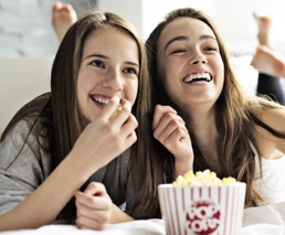 2 Mädchen schauen Film mit Popcorn