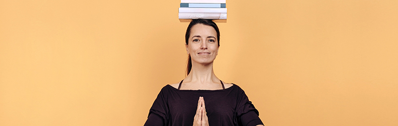 Frau balanciert Bücher und meditiert