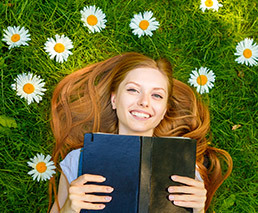 Person mit Buch in Blumenwiese